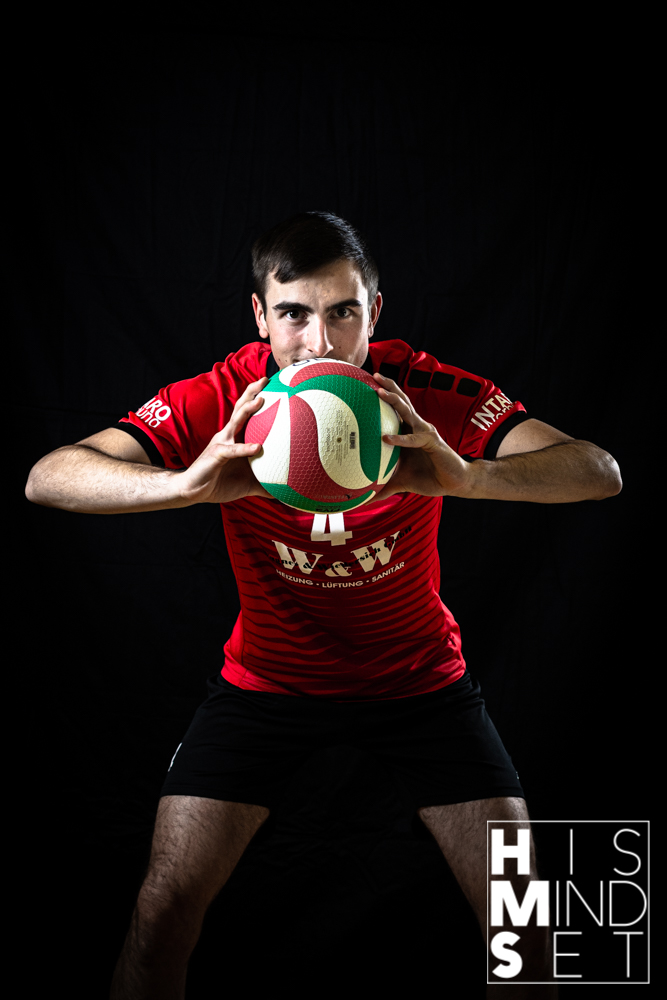 Volleyballer mit Ball vor dem Körper